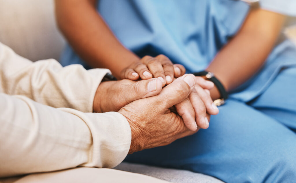 Nurse and patient holding hands in nursing home for healthcare, empathy and support.