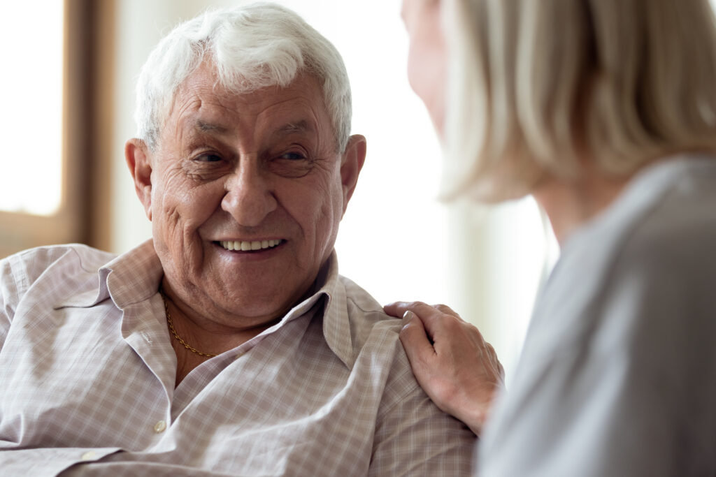 Happy older man communicating with female caregiver