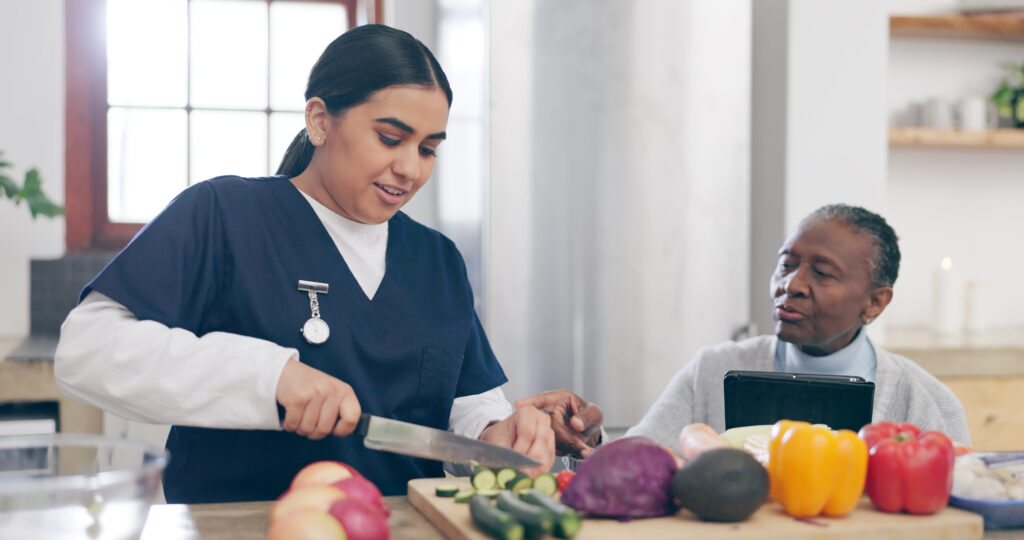 Caregiver prepares healthy foods has senior woman watches
