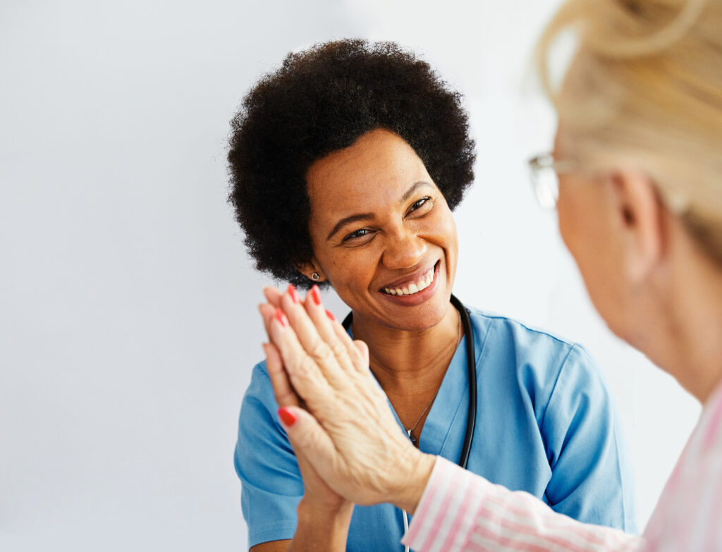 Caregiver with senior woman giving high five